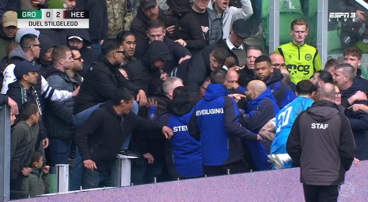 Ex-Newcastle loanee Jetro Willems is punched by one of his own fans in match match that is temporarily suspended after Groningen fans invade pitch