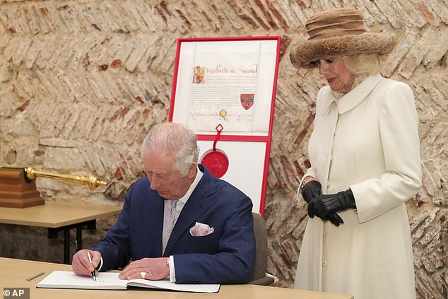 The King’s signature will now appear on all 500 certificates awarded to winners of the Queen Consort’s Coronation Champions Awards, along with that of his wife. Pictured: King Charles signs a visitors